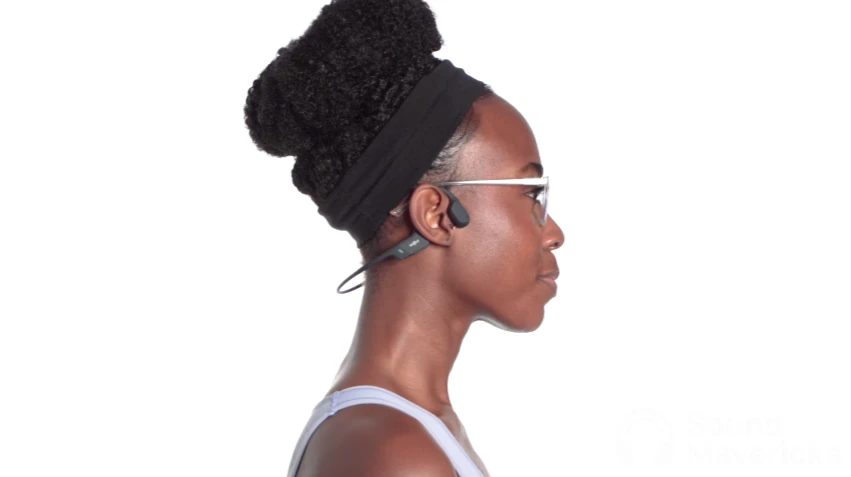 a lady showing how to put on bone conduction headphone